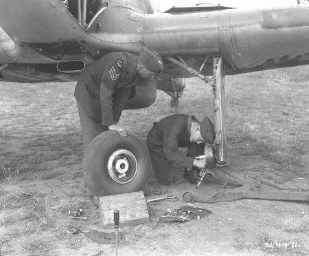 Ground crew replace the port wheel on a Hurricane.  These often forgotten, yet vital members of the RCAF, played an important role throughout the war